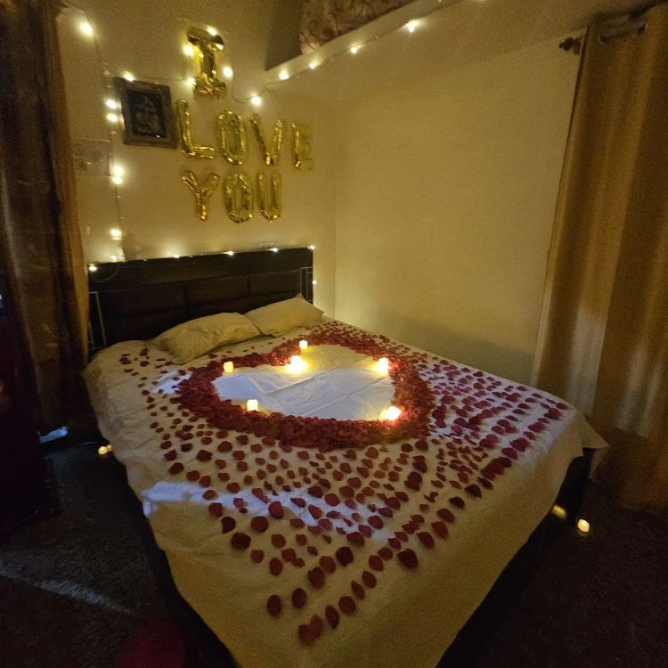 Romantic first night room decoration service in Bangalore with rose petals and candles